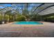 Screened-in pool featuring a brick paver deck, water feature, and mature landscaping at 32 Allenwood Look, Ormond Beach, FL 32174