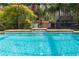 Close-up of a crystal blue screened-in pool and patio with a play area in the background at 32 Allenwood Look, Ormond Beach, FL 32174