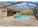 Screened-in pool area features brick pavers, a heated pool with waterfall feature, and a poolside shower at 32 Allenwood Look, Ormond Beach, FL 32174