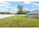 Well-maintained backyard with green lawn, secure fencing, and overhead power lines at 5297 Se 39 Loop, Ocala, FL 34480
