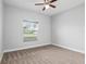 Bright bedroom with a ceiling fan, neutral carpet and paint, and a window offering plenty of natural light at 5297 Se 39 Loop, Ocala, FL 34480