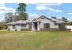 Beautiful single Gathering home featuring a lush green lawn, complemented by flowering bushes and mature trees in a tranquil setting at 5297 Se 39 Loop, Ocala, FL 34480