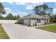 The home features a spacious driveway leading to a two-car garage and a backyard enclosed by a white fence at 5297 Se 39 Loop, Ocala, FL 34480