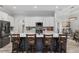 Modern kitchen boasts a large island with seating, white cabinets, stainless steel appliances, and stylish backsplash at 5297 Se 39 Loop, Ocala, FL 34480