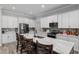 Spacious kitchen features a marble island, white cabinets, stainless steel appliances, and stylish backsplash at 5297 Se 39 Loop, Ocala, FL 34480