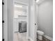 Hallway view of a laundry room with modern appliances and toilet at 5297 Se 39 Loop, Ocala, FL 34480