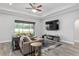 Cozy living room featuring a comfortable sectional sofa, large window, and mounted flat screen television at 5297 Se 39 Loop, Ocala, FL 34480