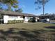Charming single-story home with a carport and well-maintained landscaping on a sunny day at 55 Sw Fig Tree Ln, Dunnellon, FL 34431