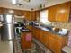 Well-lit kitchen featuring stainless steel appliances and ample cabinet space and breakfast bar at 55 Sw Fig Tree Ln, Dunnellon, FL 34431