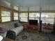 Bright sunroom with windows, comfortable seating, and a patterned rug at 55 Sw Fig Tree Ln, Dunnellon, FL 34431