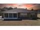 Exterior view of a home featuring an enclosed sunroom, complemented by a well-kept lawn and neutral color scheme at 6175 Sw 154Th Place Rd, Ocala, FL 34473