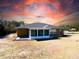 Exterior shot of a house with a sunroom and backyard, with dark clouds in the sky at 6175 Sw 154Th Place Rd, Ocala, FL 34473