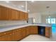 Kitchen featuring wood cabinetry, laminate countertops and views of the sunroom at 6175 Sw 154Th Place Rd, Ocala, FL 34473