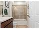 Bathroom featuring a shower over tub with glass door, white toilet, and tile floors at 9581 Sw 63Rd Loop, Ocala, FL 34481