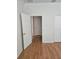 An empty bedroom featuring hardwood floors, white trim, and an ensuite bathroom view at 9581 Sw 63Rd Loop, Ocala, FL 34481