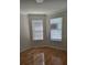 An empty room with hardwood floors, crown molding, and two windows that provide ample natural light at 9581 Sw 63Rd Loop, Ocala, FL 34481