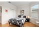 Bright bedroom with hardwood floors, closet, and an accent painting above the bed at 9581 Sw 63Rd Loop, Ocala, FL 34481