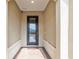 Elegant entryway with textured walls, decorative pillars, and a stylish dark-framed glass door and brick floor at 9581 Sw 63Rd Loop, Ocala, FL 34481