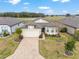 A well-maintained home features a brick-paved driveway, manicured lawn, and a spacious two-car garage at 9581 Sw 63Rd Loop, Ocala, FL 34481