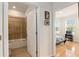 Bright hallway leads to a bedroom with wood flooring and a bathroom with a tiled tub and shower at 9581 Sw 63Rd Loop, Ocala, FL 34481