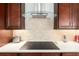 Modern kitchen with an induction cooktop, stylish backsplash, and stainless steel appliances at 9581 Sw 63Rd Loop, Ocala, FL 34481