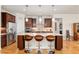 Kitchen boasts a large island with seating, stainless steel appliances, and rich wood cabinetry at 9581 Sw 63Rd Loop, Ocala, FL 34481