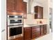 The kitchen features built-in stainless steel oven and microwave with beautiful dark wood cabinetry at 9581 Sw 63Rd Loop, Ocala, FL 34481