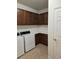 A well-organized laundry room with a washer, dryer, and plenty of storage space with brown cabinets at 9581 Sw 63Rd Loop, Ocala, FL 34481