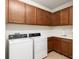 Bright laundry room with tile floor, washer, dryer, white counters, and dark brown cabinets at 9581 Sw 63Rd Loop, Ocala, FL 34481