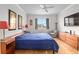 Bright main bedroom boasts wood floors, large window and ceiling fan at 9581 Sw 63Rd Loop, Ocala, FL 34481
