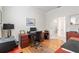 Well-lit office with wood floors, bright walls, and a desk features french doors and an adjacent room at 9581 Sw 63Rd Loop, Ocala, FL 34481