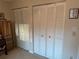 Bedroom featuring two large white louvered closet doors at 9638 Sw 94Th Ct # A, Ocala, FL 34481