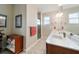 Well-lit bathroom with double sinks, a framed mirror, and a glass-enclosed shower at 9704 Sw 95Th Loop, Ocala, FL 34481