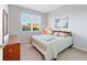 Sunlit bedroom with a bed, dresser, and serene beach-themed artwork at 9704 Sw 95Th Loop, Ocala, FL 34481