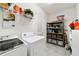 Functional laundry room equipped with washer, dryer, storage shelves, and a hanging rack at 9704 Sw 95Th Loop, Ocala, FL 34481