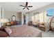 Bright main bedroom featuring a ceiling fan, natural light, and neutral color palette with comfortable furnishings at 9704 Sw 95Th Loop, Ocala, FL 34481