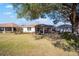 Home exterior featuring a screened-in enclosure with a grassy backyard at 9895 Sw 95Th Loop, Ocala, FL 34481