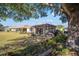 Backyard view with a large tree shading the screened enclosure and grassy area at 9895 Sw 95Th Loop, Ocala, FL 34481