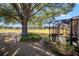 Backyard view with a large tree shading the screened enclosure at 9895 Sw 95Th Loop, Ocala, FL 34481