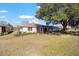 Backyard featuring a screened-in porch, well-maintained lawn, and mature trees at 9895 Sw 95Th Loop, Ocala, FL 34481