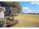 Exterior view of the screened-in lanai and backyard overlooking the grassy area at 9895 Sw 95Th Loop, Ocala, FL 34481