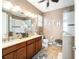Bright bathroom featuring double sink vanity, tiled floors, and glass enclosed shower at 9895 Sw 95Th Loop, Ocala, FL 34481