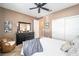 Cozy bedroom featuring a ceiling fan, comfortable bed, and dresser with decorative mirror at 9895 Sw 95Th Loop, Ocala, FL 34481