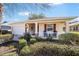 Exterior of home featuring well-manicured landscaping and rocking chairs on the porch at 9895 Sw 95Th Loop, Ocala, FL 34481