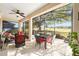 Screened lanai with seating area, ceiling fan, and view of expansive backyard at 9895 Sw 95Th Loop, Ocala, FL 34481