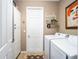 Functional laundry room equipped with a washer, dryer, storage cabinet and laundry-themed decor at 9895 Sw 95Th Loop, Ocala, FL 34481