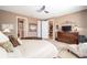 Serene main bedroom with a ceiling fan, dresser, and views into other living spaces at 9895 Sw 95Th Loop, Ocala, FL 34481