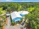 Aerial view of the community building featuring a bright blue exterior, white roof and ample parking at 9910 Sw 189Th Cir, Dunnellon, FL 34432