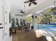 Covered lanai featuring ceiling fans, chandelier, and access to a sparkling pool at 9910 Sw 189Th Cir, Dunnellon, FL 34432