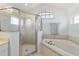 Bathroom featuring a soaking tub and glass-enclosed shower with tile surround at 10080 Se 68Th Ct, Belleview, FL 34420